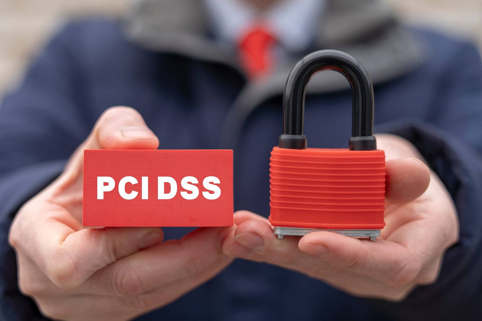 Lock and PCI DSS symbol held in hands, signifying defense against a PCI DSS non-compliance charge.