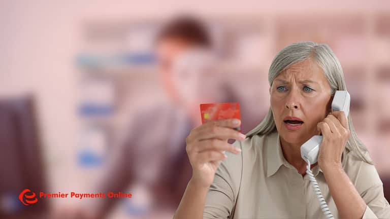 Woman holding credit card while calling bank about payment fraud analytics and suspicious transactions"